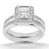 A silver engagement ring featuring a square-cut center stone surrounded by smaller gemstones on a two-band design.