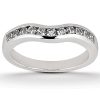 A silver wedding band with a curved design features a row of small, clear gemstones along the upper edge.