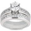 A silver ring set featuring a large round diamond center stone with smaller diamonds on either side.
