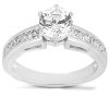 A silver ring with a large round diamond at the center and smaller diamonds set along the band.