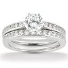 A diamond engagement ring featuring a large round center stone and delicate bands embellished with smaller diamonds.