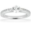A diamond engagement ring with a round center stone and small accent stones set along the band.