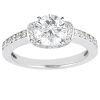 A silver engagement ring features a large round diamond at its center, surrounded by smaller accent stones along the band.