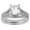 A silver engagement ring features a large round diamond center stone with smaller diamonds set along the band.