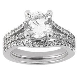 A silver engagement ring features a large round diamond center stone with smaller diamonds set along the band.
