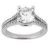 A silver engagement ring features a round, clear gemstone in a four-prong setting with smaller stones along the band.