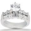 A silver engagement ring features a large central round diamond surrounded by smaller diamonds and rectangular cut stones.