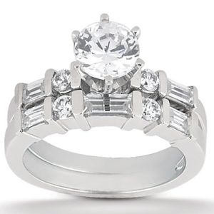 A silver engagement ring features a large central round diamond surrounded by smaller diamonds and rectangular cut stones.