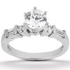 A silver engagement ring features a large round center stone flanked by two smaller stones and two rectangular stones on each side.