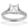 A silver engagement ring with a large princess-cut clear diamond in the center and smaller stones set along the band.