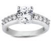 A silver engagement ring features a large central diamond surrounded by smaller diamonds along the band.