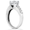 A silver engagement ring with a central round diamond and smaller diamonds set along the band.