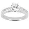 A silver engagement ring featuring a large round diamond center stone and smaller diamonds set along the band.