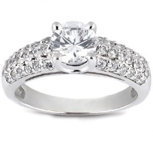 A silver ring features a large central diamond surrounded by smaller sparkling stones on its band.