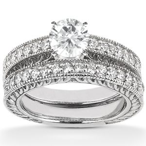 Silver engagement ring set featuring a large round center diamond and intricate pave detailing on the band.
