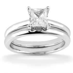 A silver wedding ring set featuring a solitaire princess-cut diamond on the top ring and a plain band below.