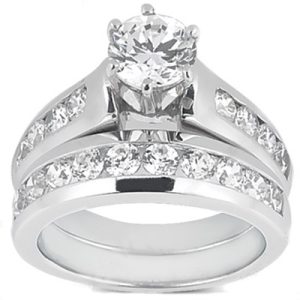 A silver engagement ring set featuring a prominent round diamond surrounded by smaller diamonds on the band.