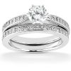 A diamond engagement ring set featuring a round center stone and a band with small accent diamonds.