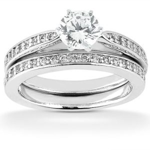 A diamond engagement ring set featuring a round center stone and a band with small accent diamonds.