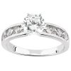 A silver ring features a prominent round diamond in the center, flanked by smaller triangular diamonds on each side.