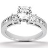 A silver engagement ring with a large central clear stone and two smaller stones on either side is displayed prominently.