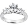 A diamond ring with a central round-cut stone flanked by two smaller rectangular-cut stones on a silver band.