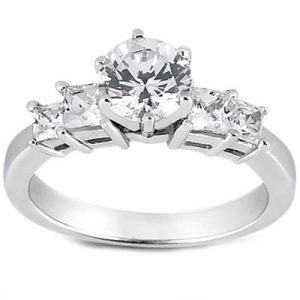 A diamond ring with a central round-cut stone flanked by two smaller rectangular-cut stones on a silver band.