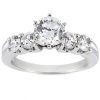 A silver ring with a central round-cut diamond and three smaller diamonds on each side.