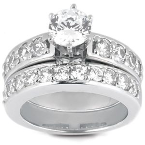 A silver wedding ring set featuring a central round diamond and smaller diamonds embedded in the band.