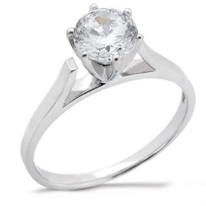 A silver ring with a large, clear gemstone is displayed prominently.