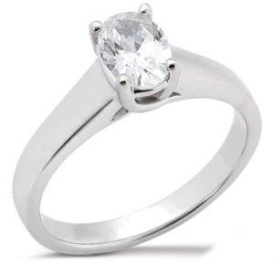 An oval-cut diamond is set in a white gold engagement ring.