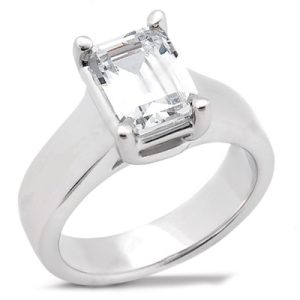 A silver ring features a large, clear, rectangular gemstone set in a four-prong setting.