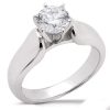 A silver engagement ring features a large round diamond held by six prongs.