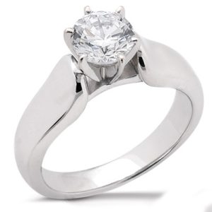 A silver engagement ring features a large round diamond held by six prongs.