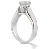 A silver engagement ring with a prominent diamond is displayed from a side angle.