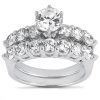 A silver ring features a central round diamond surrounded by smaller diamonds in a tiered arrangement.