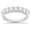 A silver ring features a row of eight round clear stones elegantly set in a smooth band.