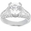 A silver ring featuring a large, round clear gemstone surrounded by smaller clear stones set in a decorative band.