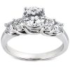 A silver ring with a large central diamond flanked by three smaller diamonds.