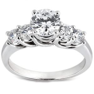 A silver ring with a large central diamond flanked by three smaller diamonds.