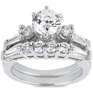 A silver engagement ring featuring a large central round diamond surrounded by smaller diamonds and baguette-cut stones.