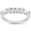 A silver ring features five prominently displayed round gemstones with two tapered baguette diamonds on either side.