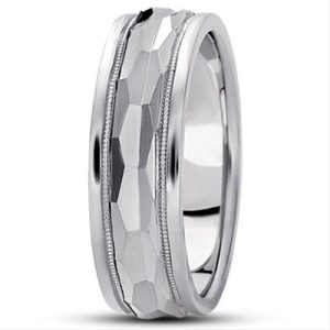 A silver wedding band with a faceted surface and a textured edge.