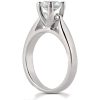 A silver engagement ring with a large clear diamond is positioned at an angle to highlight its setting and shape.