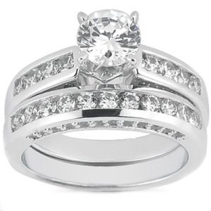 A silver engagement ring features a large central round diamond with smaller diamonds set along the curved band.