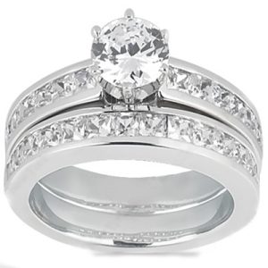 A silver engagement ring set featuring a prominent round gemstone surrounded by smaller stones along the band.