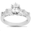 A silver engagement ring features a large round center stone with two trapezoidal stones on either side.