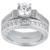 A silver engagement ring with a large, round diamond surrounded by smaller stones on a textured band.