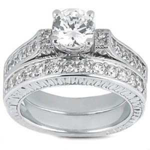 A silver engagement ring with a large, round diamond surrounded by smaller stones on a textured band.