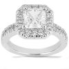 A square-cut diamond engagement ring with a halo of smaller diamonds set in a white metal band is prominently displayed.